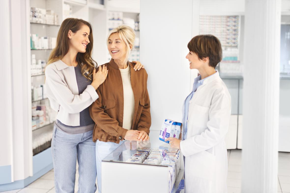Ältere Patientin mit Tochter in der Apotheke werden von Apothekerin beraten - verlinkt zu Fresubin auf Rezept (Wo ist Fresubin erhältlich)