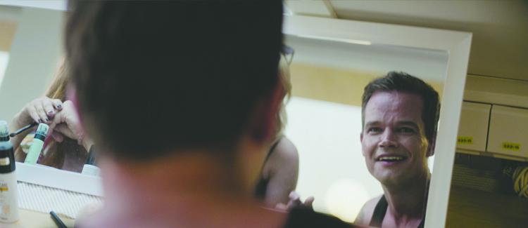 Man looking in the mirror & smiling