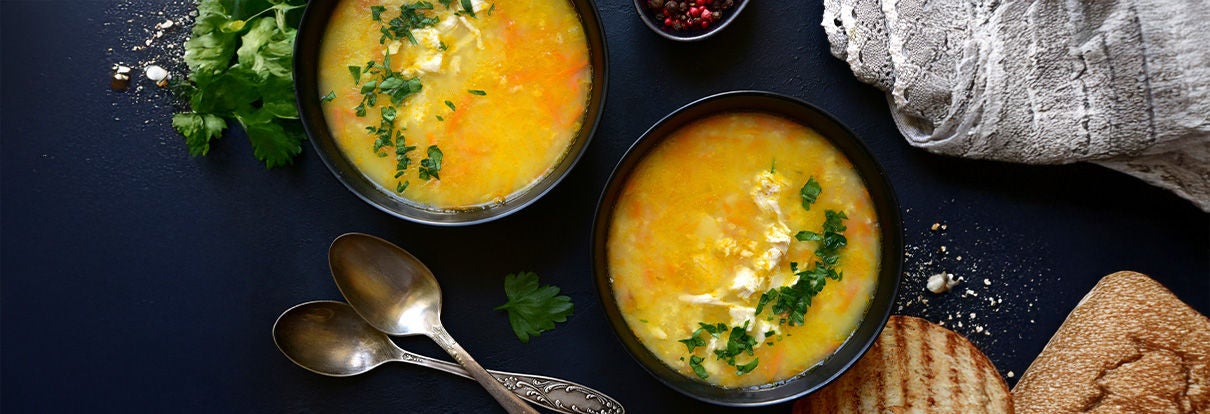 Geflügelsuppe in zwei Suppenschalen mit Petersilie