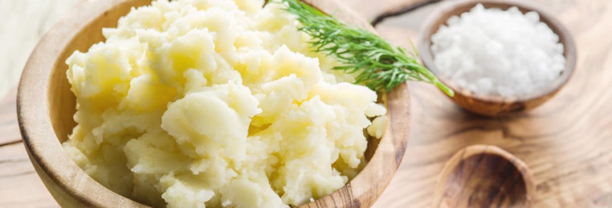 Kartoffelbrei in einer Holzschüssel mit einer kleinen Schale Salz nebendran