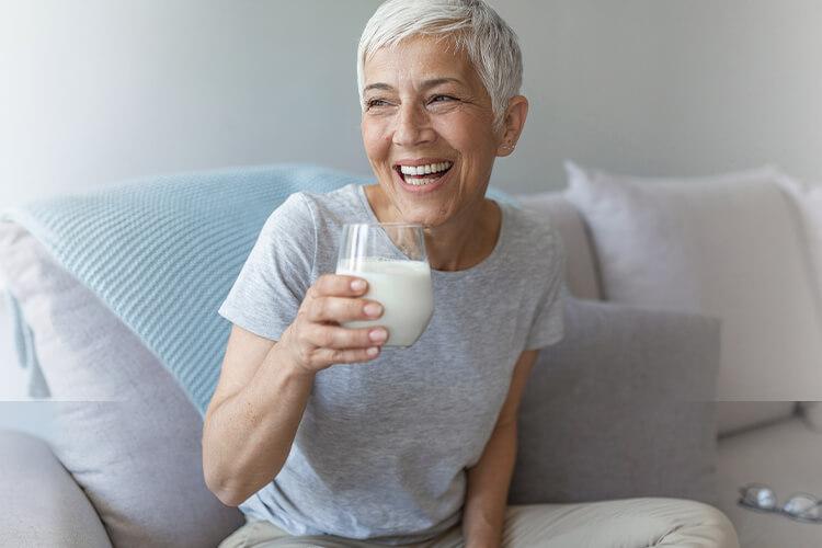Kvinne som sitter og drikker fra ett glass