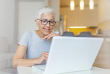 Kvinne som leser på laptop