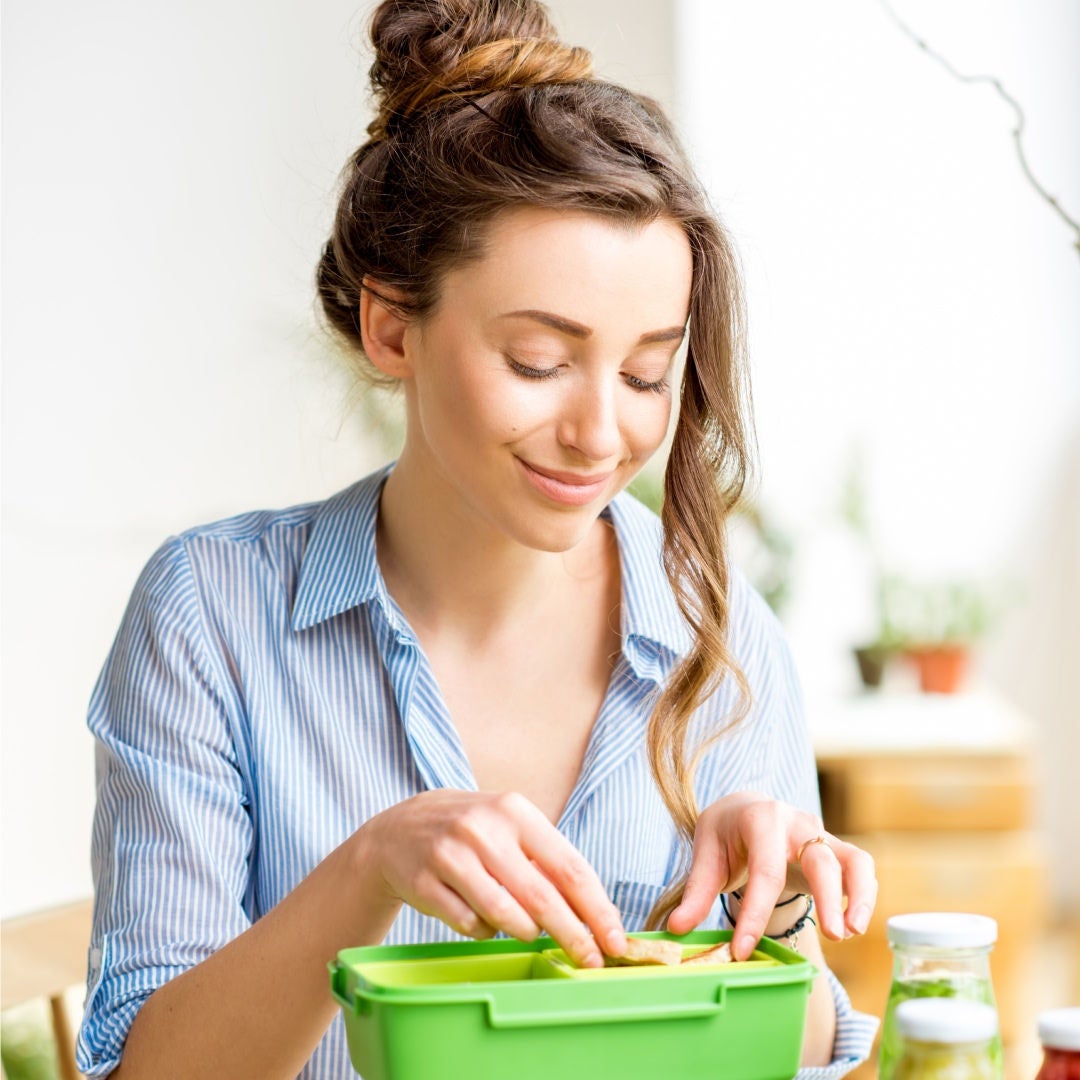 Jonge vrouw met gele t-shirt die lacht en een fresubin plant-based drink in de hand heeft.