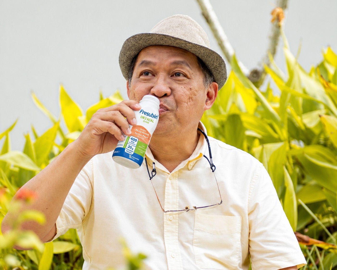 Dans son jardin, un homme savoure une boisson Diben à la vanille afin de répondre à ses besoins nutritionnels en tant que personne atteinte de diabète. 