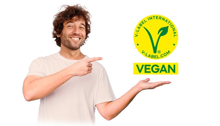 Smiling man pointing to the official V-Label International Vegan certification logo, highlighting Fresubin Plant-Based as a 100% vegan medical nutrition option.