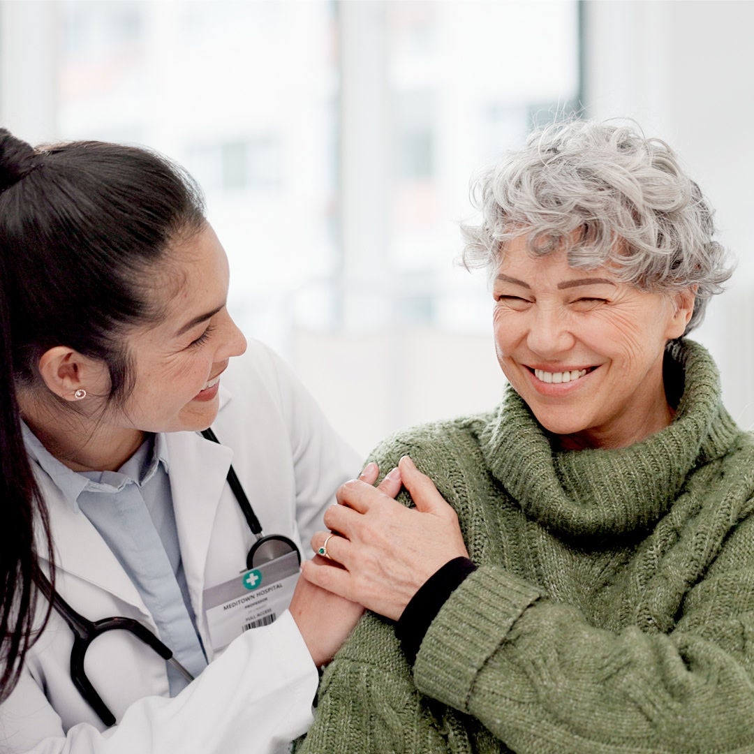 A healthcare professional smiles with a female patient, knowing that her care is supported by Fresubin's product range, including Protein Shots. 