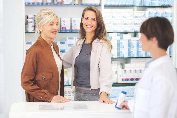 Ältere Patientin mit Tochter in der Apotheke werden von Apothekerin beraten - verlinkt zu Fragen & Antworten