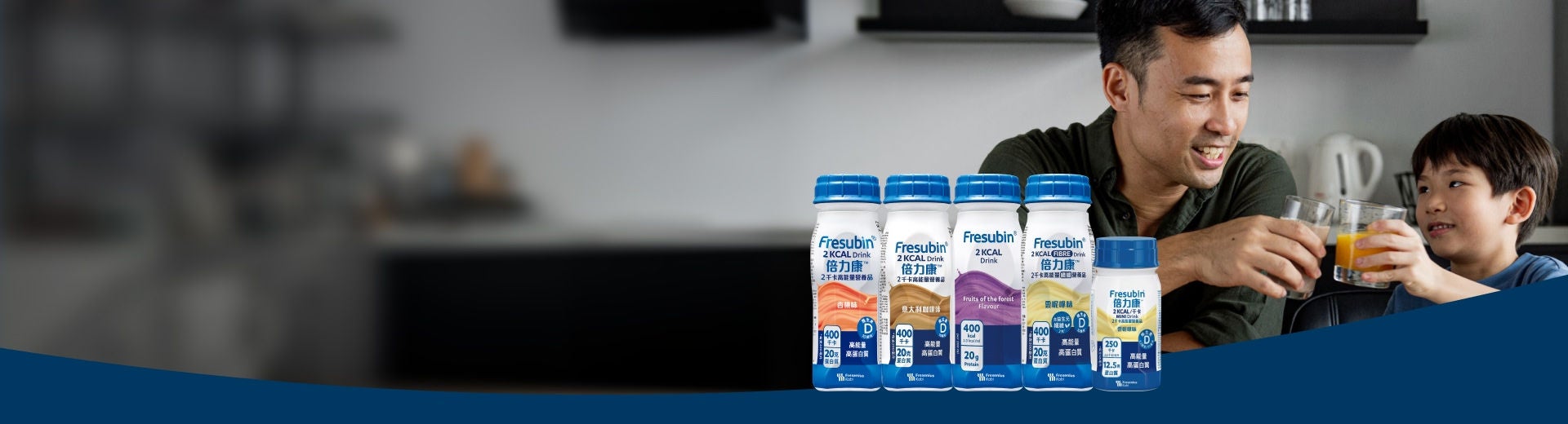 A smiling man sits with a young boy at a kitchen counter, with the Fresubin 2KCAL product range displayed in the foreground, including Fresubin Chocolate-flavoured 2KCAL FIBRE Drink, Fresubin Cappuccino-flavoured 2KCAL Drink, Forest Fruits 2KCAL COMPACT Drink, and 2KCAL Crème in Wild Strawberry and Praline flavours. 