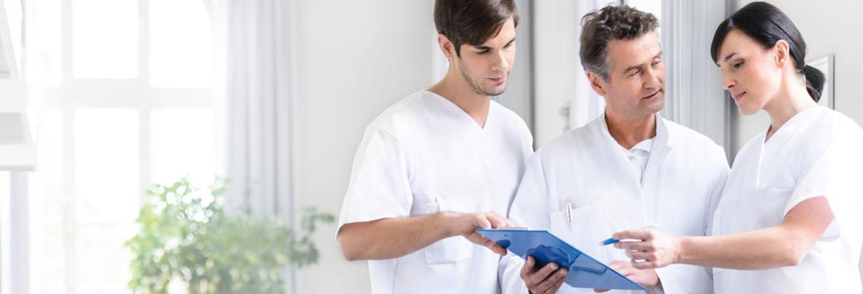 Arzt im Gespräch mit Pflegern über rechtliche Hinweise