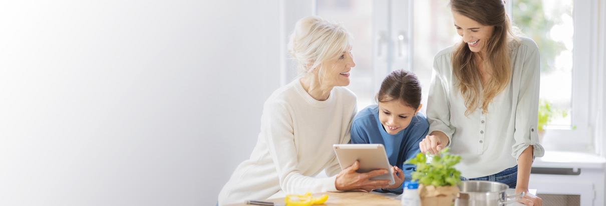 Patientin mit Enkelin und Ernährungsberaterin in der Küche – Eine Ernährungstherapie kann die Lebensqualität bei vielen Erkrankungen positiv beeinflussen