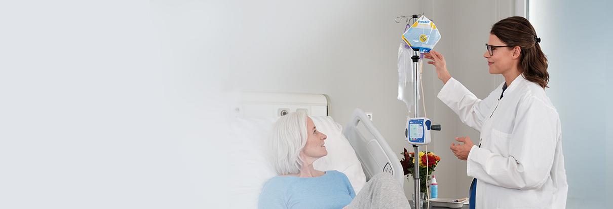 Fresubin Sondennahrung - Patientin im Krankenhausbett wird von einer Ärztin mit Fresenius Sondennahrung versorgt.