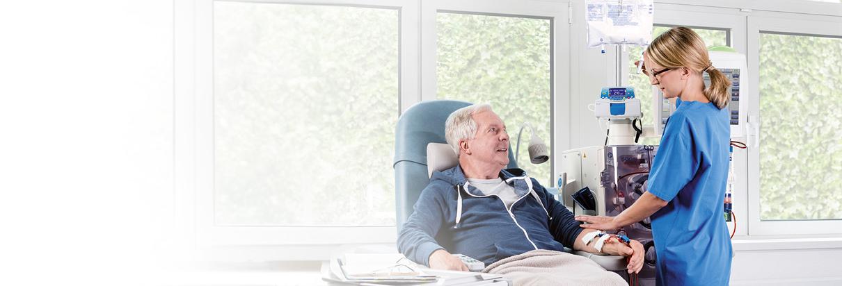 Patient während der Dialysebehandlung unterhält sich mit einer Pflegerin, die ihn an ein Dialysegerät anschließt - die richtige Ernährung bei Dialyse spielt eine wichtige Rolle für die Nährstoffversorgung.