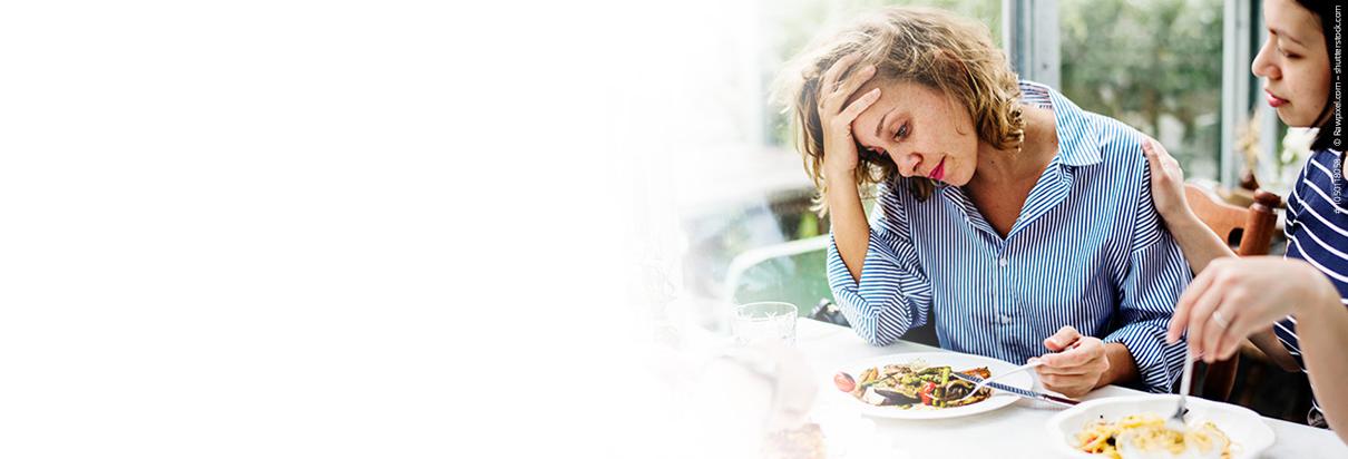 Mangelernährung: Frühzeitig erkennen und effektiv behandeln - Frau ist über ihr Essen gebeugt und hat keinen Appetit,  wobei Fresubin Trinknahrung unterstützen kann, um einer Mangelernährung entgegenzuwirken.