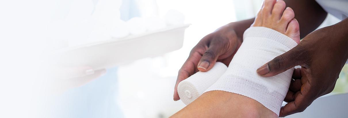 Wundheilung und Ernährung: Eine Krankenpflegerin verbindet den Fuß eines Patienten