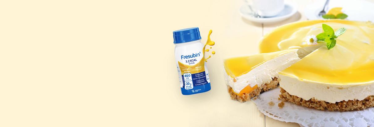 angeschnittener Mango-Käse-Kuchen mit der Trinknahrung Fresubin 5 KCAL Shot in der Geschmacksrichtung Mango