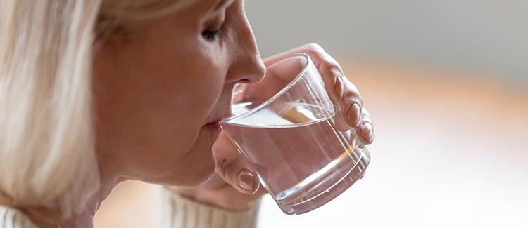 elderly woman drinking glass of water