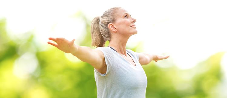 woman spreads arms in nature