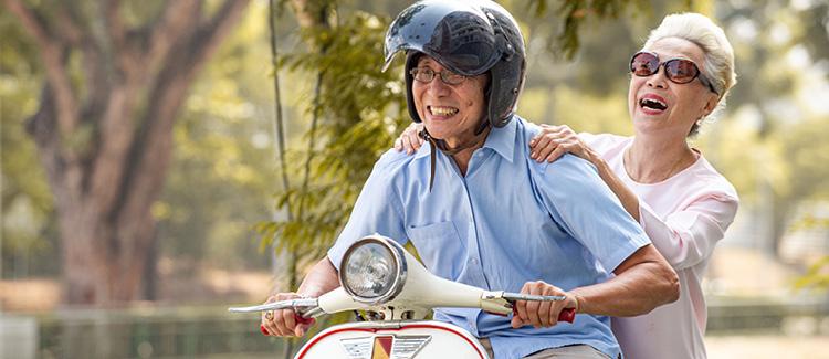 elderly couple on a vespa driving