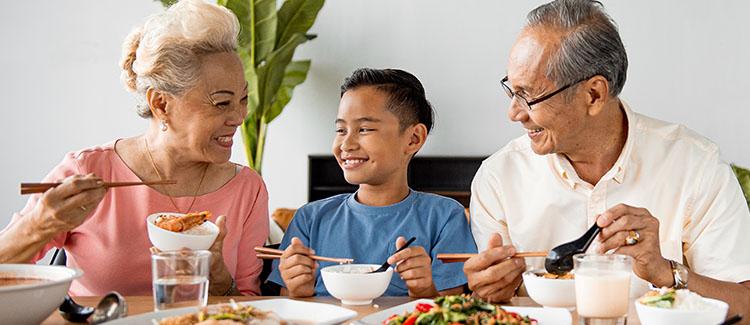child and grandparents having lunch 